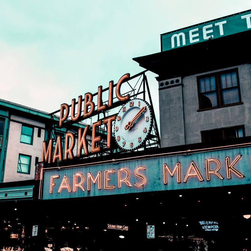 A colorful market building sign reads &ldquo;DUBLINIC MARKET&rdquo; with a large clock face and &ldquo;FARMERS MARKET&rdquo; lettering.